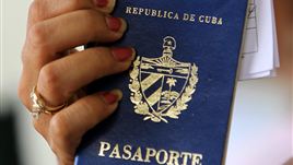 A woman holds up a Cuban passport in a regional immigration office in Havana (Cuba).