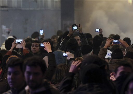 People use mobile devices to record as riot police use a water cannon to disperse protesters during a rally against a bill which would, among other things, allow Turkey's authorities to block web pages for privacy violations without a prior court decision, in Istanbul, Turkey, late Saturday, Feb. 22, 2014. Police in Istanbul have clashed with hundreds of protesters denouncing a new law that increases government controls over the Internet. (AP Photo/Emrah Gurel)