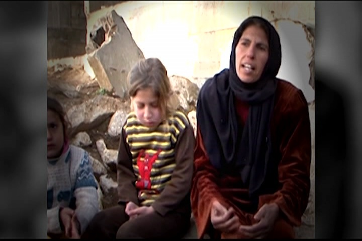 syrian refugees, woman and her child sit on the ground